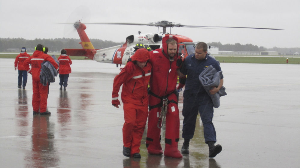 On a runway at a North Carolina air station, Coast Guard members assist one of the 14 sailors rescued after the Bounty entered the path of Hurricane Sandy and sank in 2012.