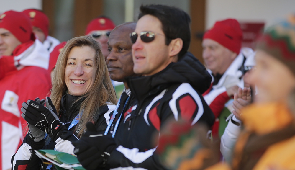 Angelica Morrone di Silvestri, left, and her husband, Gary, center, are representing the Caribbean nation of Dominica in the Olympics. She qualified in a Maine race.