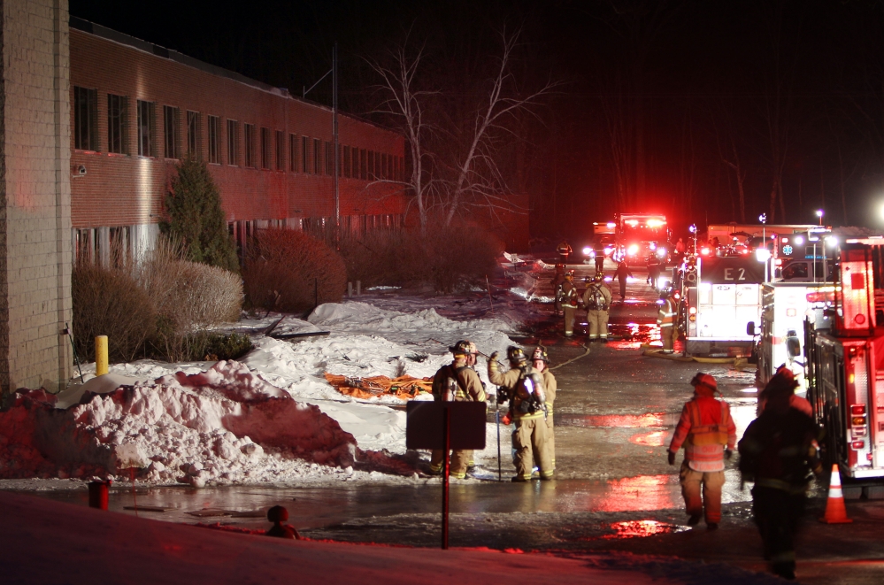 Emergency crews from several towns work outside the New Hampshire Ball Bearing plant after an explosion Monday in Peterborough, N.H.