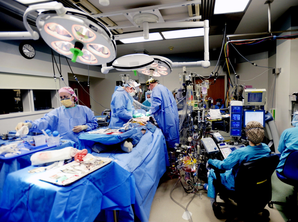 A surgery takes place in a crowded operating room at Maine Medical Center on Tuesday. Maine Med has received state approval for a $40 million expansion that will allow it to add several operating rooms.