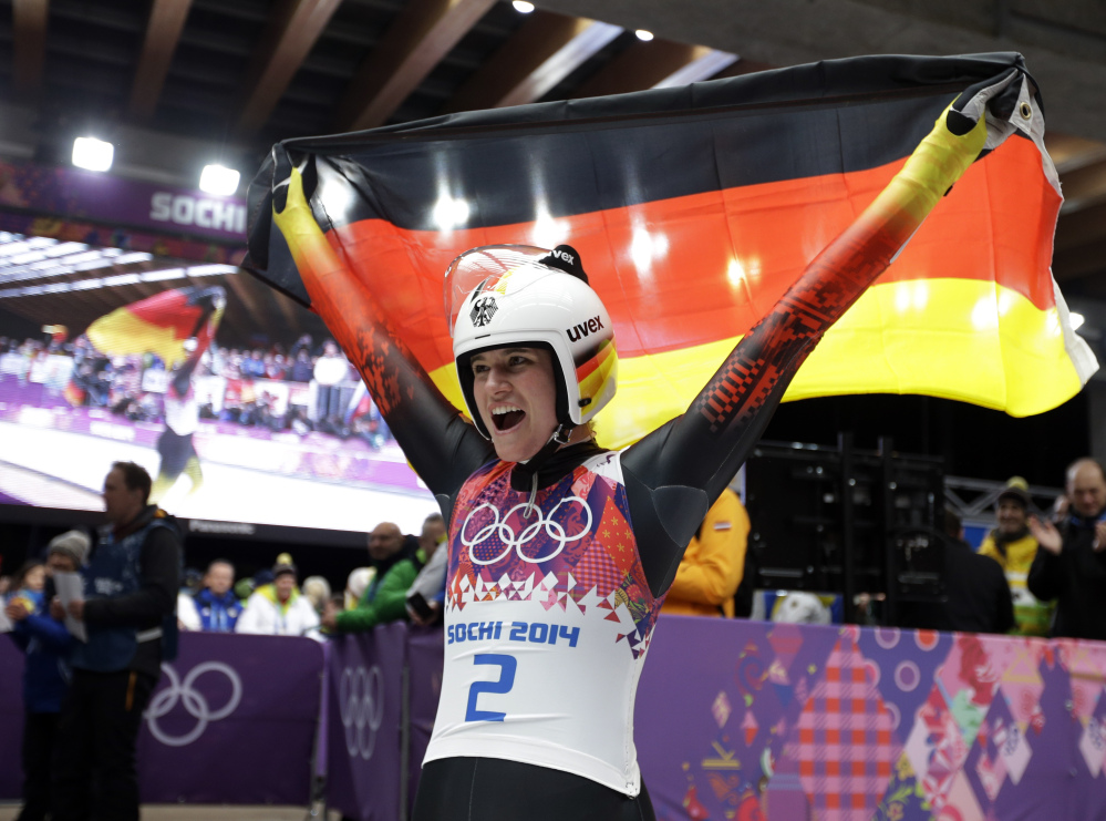 Natalie Geisenberger of Germany waves the flag after finishing her final run to win the gold medal during the women’s singles luge competition.