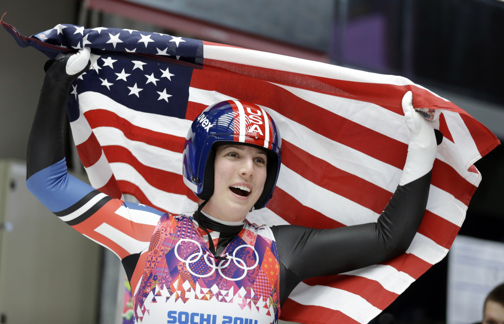 Erin Hamlin of the United States waves the flag after finishing her final run to win the bronze medal during the women’s singles luge competition at the 2014 Winter Olympics.