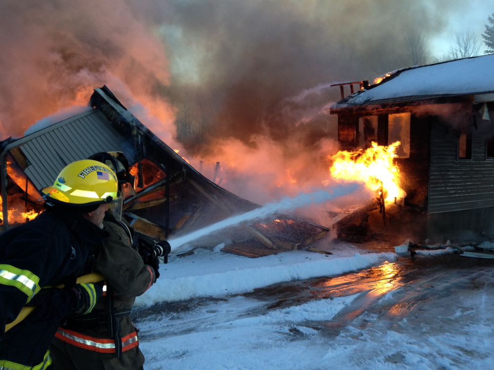 TOTAL LOSS: Firefighters from several communities work at the the scene of a fire Tuesday on Rose Lane in Farmingdale.