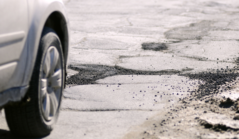 Staff photo by Joe Phelan Cars drive past cracked pavement and filled potholes on Mount Vernon Avenue on Tuesday February 11, 2014 in Augusta.