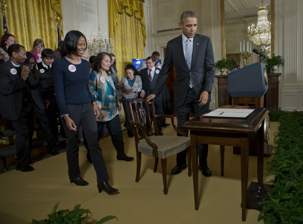 President Barack Obama prepares to take his seat before signing an executive order to raise the minimum wage for federal contract workers, Wednesday, during a ceremony in the East Room of the White House in Washington.