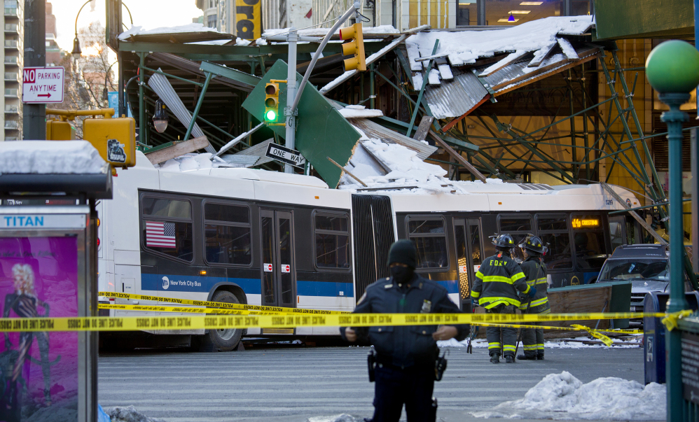 A Metropolitan Transportation Authority bus rests against scaffolding at 14th Street and 7th Avenue in New York, Wednesday, after an early morning collision between the bus and a truck.