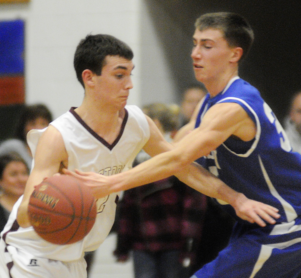 Staff photo by Andy Molloy HARD-FOUGHT AFFAIR: Monmouth Academy’s Brett Wilson, left, gets the ball knocked away by Madison Area Memorial High School’s Chase Malloy during a basketball match up Wednesday in Monmouth.