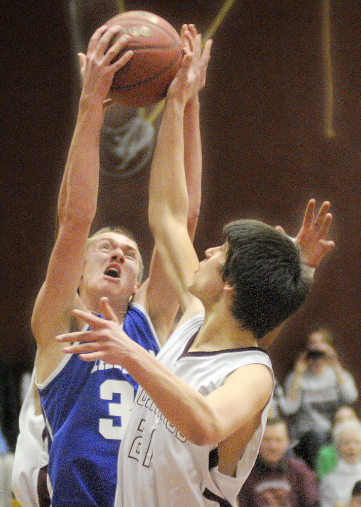 Staff photo by Andy Molloy HARD-FOUGHT AFFAIR: Monmouth Academy’s Kasey Smith, right, blocks Madison Area Memorial High School’s Dustin West during a basketball match up Wednesday in Monmouth.
