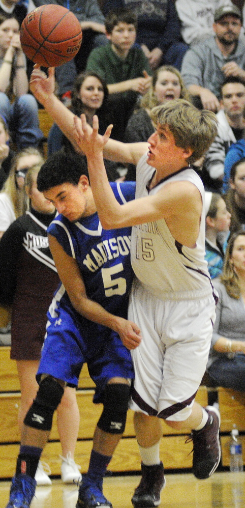 Staff photo by Andy Molloy HARD-FOUGHT AFFAIR: Monmouth Academy’s Hunter Richardson, right, collects the ball while being guarded by Madison Area Memorial High School’s Derek LeBlanc during a basketball match up Wednesday in Monmouth.