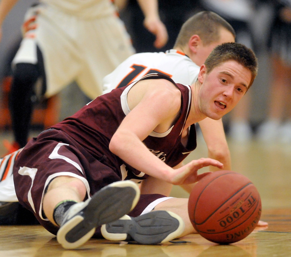 Staff photo by Michael G. Seamans HIGH SCHOOL BASKETBALL: Foxcroft Academy's Sam Keane, 24, foreground battles for the loose ball with Winslow High School's Justin Kervin, 15, in Winslow on Wednesday.