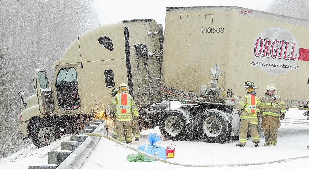 ICY ACCIDENT: Sparks fly as Winthrop firefighters cut the guard rail so that a jackknifed tractor-trailer stuck on it can get towed away on Thursday following a collision between it and a car on U.S. Route 202 in Winthrop.
