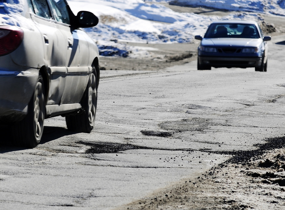 ROUGH ROAD: Cars drive past cracked pavement and filled potholes on Mount Vernon Avenue on Tuesday in Augusta.