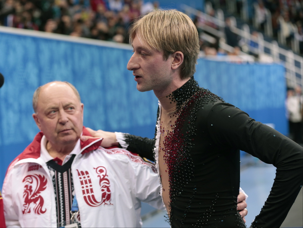Evgeni Plushenko of Russia and his coach Alexei Mishin leave after Plushenko pulled out of the men’s short program figure skating competition due to illness at the Iceberg Skating Palace during the 2014 Winter Olympics on Thursday in Sochi, Russia. Plushenko later announced he will retire.