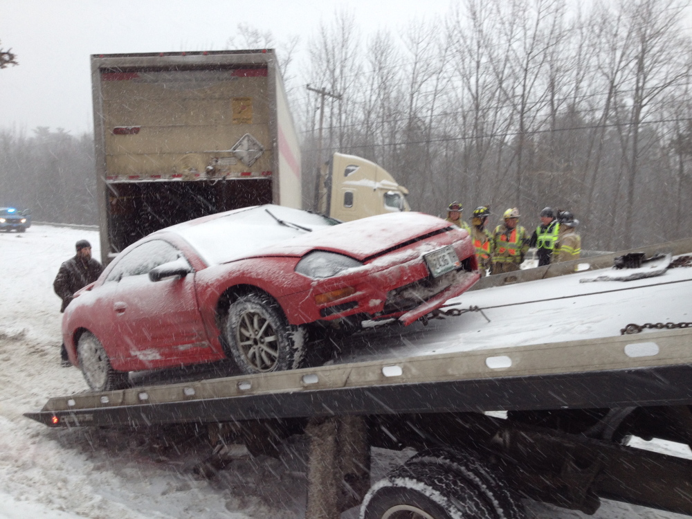 A car is mounted on a flatbed trailer to be towed away following a crash on U.S. Route 202.