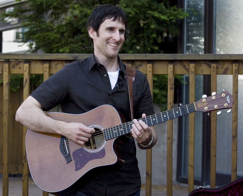 Musician Dave Carroll, of the pop-folk band Sons Of Maxwell, holds his repaired Taylor guitar in Halifax, Nova Scotia. Carroll became an Internet sensation after posting a revenge song about airline customer service on YouTube with his song “United Breaks Guitars.”