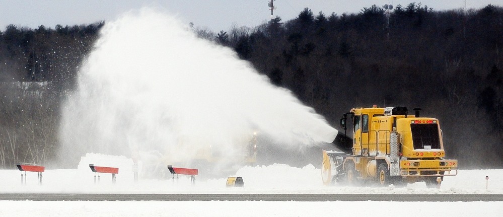 CLEARING THE WAY: A large snowblower works to clean up from the recent snow storm on Friday at the Augusta State Airport.