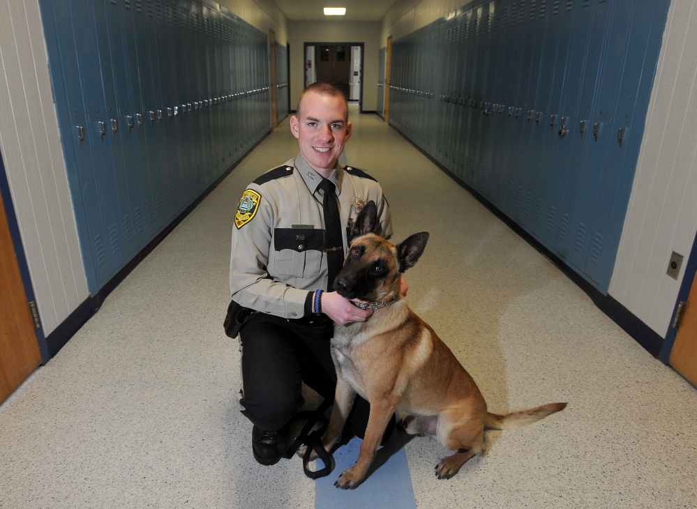Staff photo by Michael G. Seamans Aaron Moody, a deputy with the Kennebec County Sheriff's office and his partner Striker, at Lawrence High School in Fairfield on Friday. Deputy Moody is the district's school resource officer.