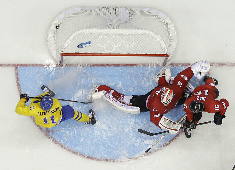 Sweden forward Daniel Alfredsson (11) scores a goal against Switzerland goaltender Reto Berra in the third period of a men’s ice hockey game at the 2014 Winter Olympics, Friday, Feb. 14, 2014, in Sochi, Russia. Sweden won 1-0.