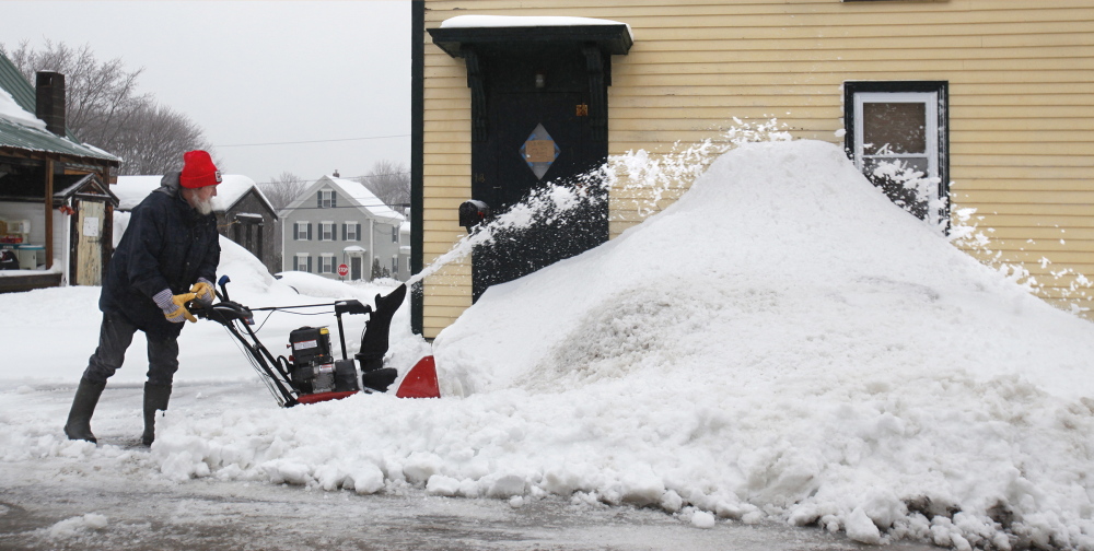 Ernest Brown clears waterlogged snow Friday from his driveway on Hovey Street in Kennebunk.