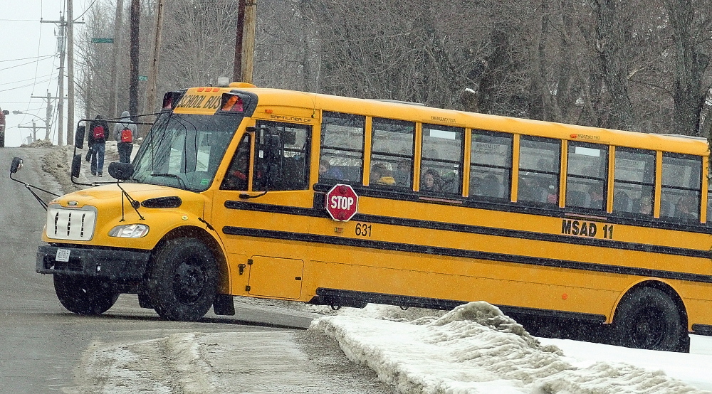 EARLY DISMISSAL: Students leave Gardiner Area High School by bus and foot as snow starts falling around 11:30 a.m. on Thursday in Gardiner. Many local schools let out early Thursday, and some stayed closed on Friday, as a snow storm blew through the area.