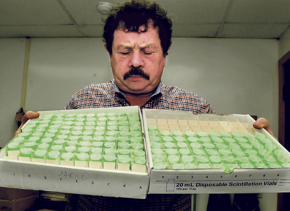 SPIKE IN WORK: Northeast Lab Services owner Rodney Mears holds two trays of water samples that will be tested for radon at the Winslow laboratory. Mears said the company used to do 6,000 samples a year and now does 6,000 samples a month.