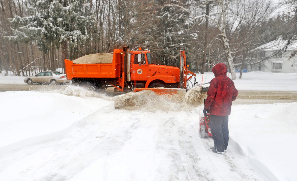 DIGGING OUT: Luke Violette, 17, watches as a plow pushes more snow onto his recently cleared driveway Friday on Mayflower Hill Drive in Waterville.