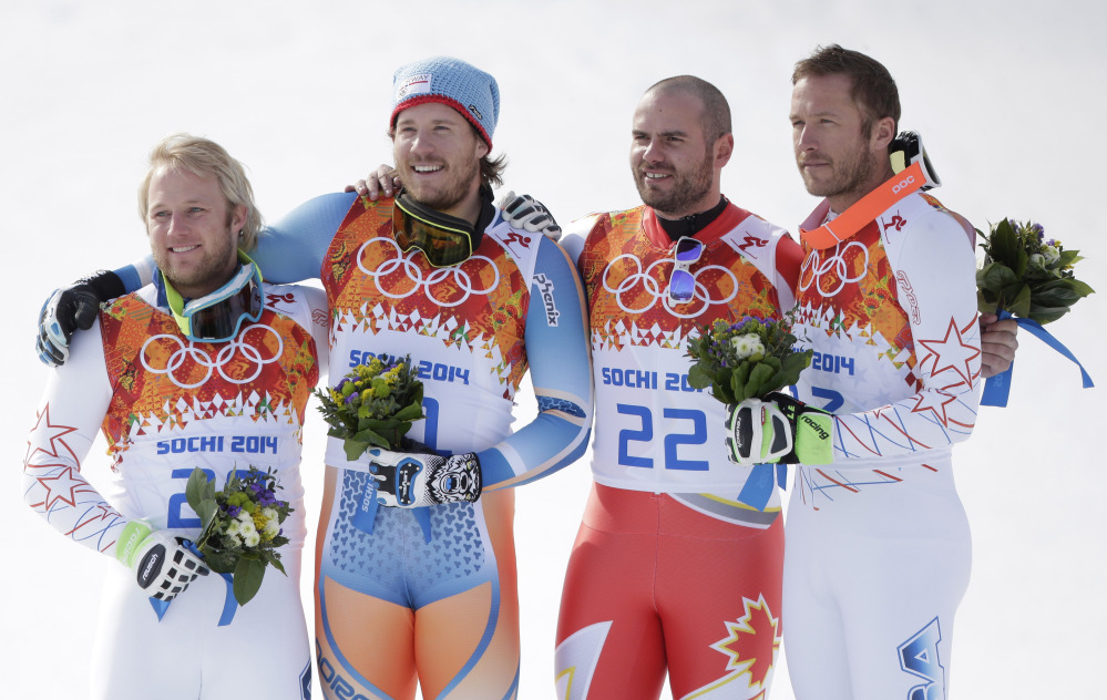 Men’s super-G medalists from left, United States’ Andrew Weibrecht (silver), Norway’s Kjetil Jansrud (gold), Canada’s Jan Hudec (bronze) and United States’ Bode Miller (bronze) pose for photographers on the podium for a flower ceremony at the Sochi 2014 Winter Olympics.