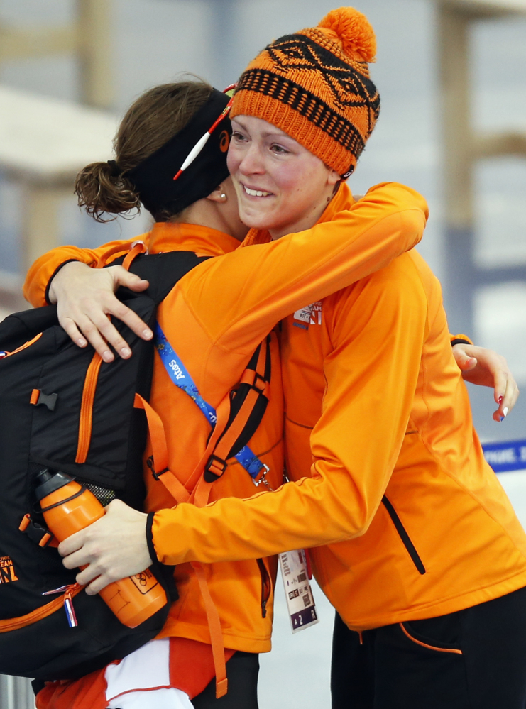An emotional gold medalist Jorien ter Mors of the Netherlands, right, is congratulated by silver medalist Ireen Wust after the women’s 1,500-meter speedskating race at the Adler Arena Skating Center during the 2014 Winter Olympics in Sochi, Russia Sunday.