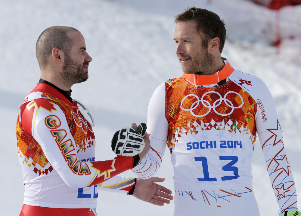 Men’s super-G joint bronze medal winners Canada’s Jan Hudec and United States’ Bode Miller shake hands on the podium during a flower ceremony at the Sochi 2014 Winter Olympics on Sunday in Krasnaya Polyana, Russia.