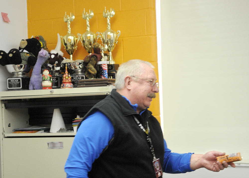 CONDITIONING: Retired teacher and Academic Decathlon coach Scott Foyt hands out crackers to Monmouth Academy’s Academic Decathon team during a recent practice. Foyt and his wife, Cathy, have coached the school’s team for several years at the Monmouth school.