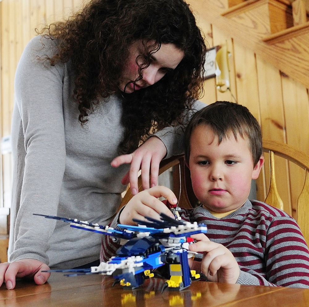 BUILDING: Kimberlee Lewis, left, helps her brother, Nate Lewis, build a Lego set that their father, Maj. Scott Lewis, sent him as a Valentine’s Day gift on Friday February 14, 2014, in Monmouth.