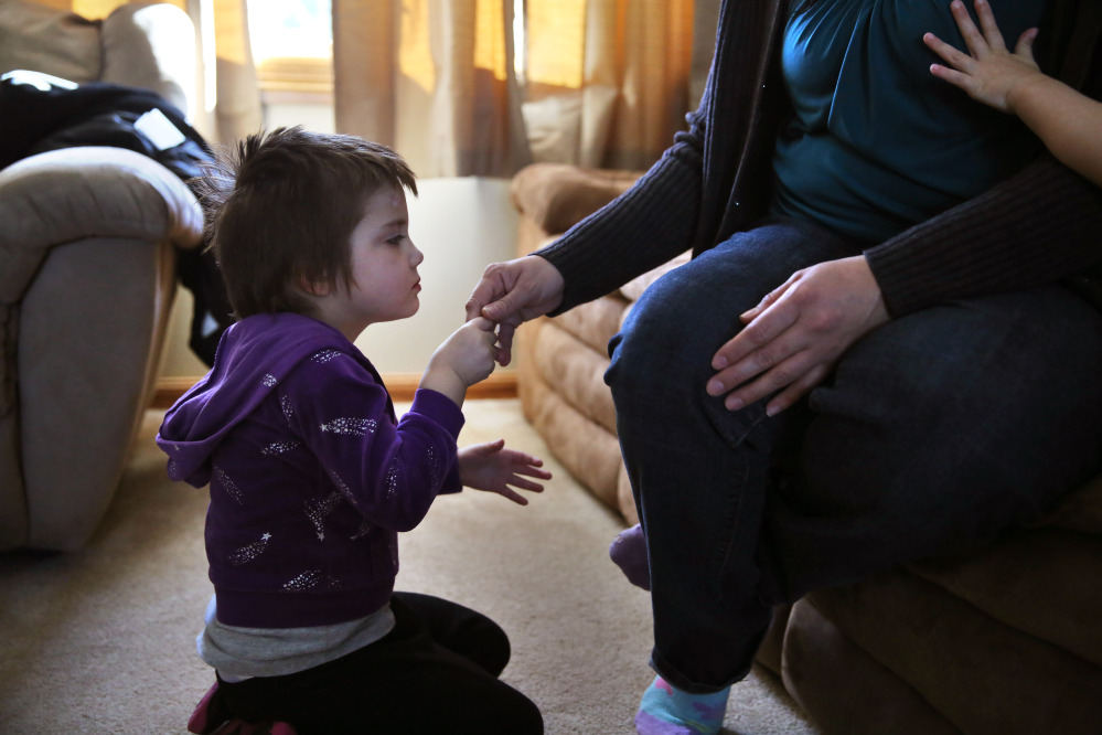Elizabeth Burger, 4, holds her mother’s hand at home in Colorado Springs, Colo. Elizabeth suffers from severe epilepsy and is receiving experimental treatment with a special strain of medical marijuana, which she takes orally as drops of oil.