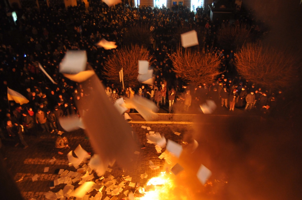 Ukrainian protesters throw out and burn papers from prosecutor’s headquarters in Lviv, western Ukraine, early Wednesday.