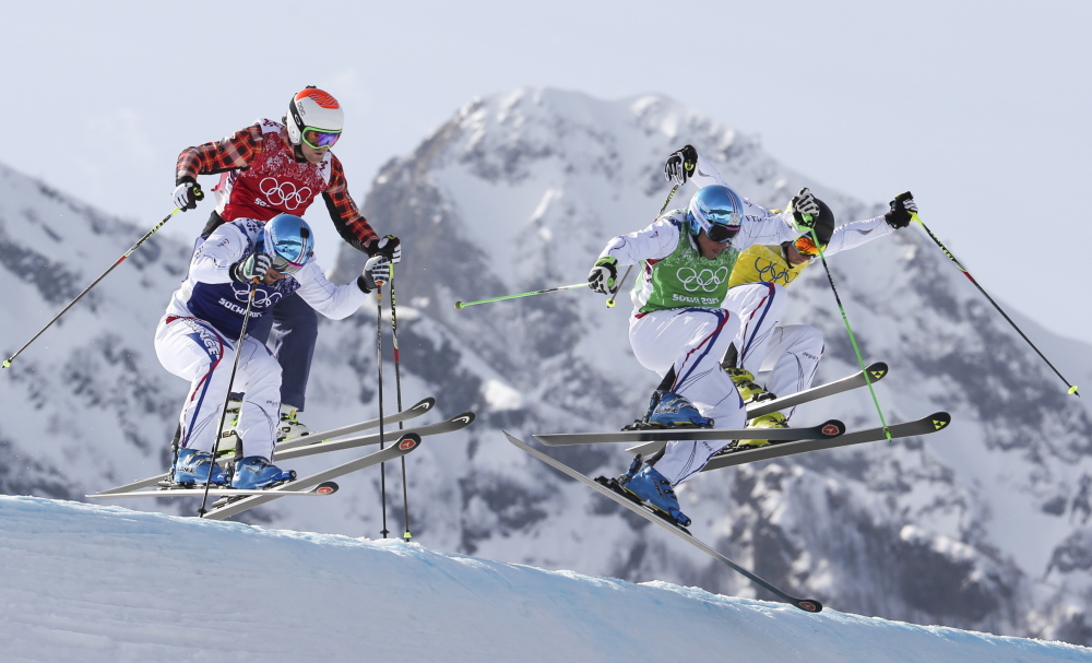 Jean Frederic Chapuis, front right, Arnaud Bovolenta, front left, Jonathan Midol, all of France, background right, and Brady Leman of Canada, background left, compete in the men’s ski cross final at the 2014 Winter Olympics on Thursday. Chapuis won ahead of Bovolenta and Midol.