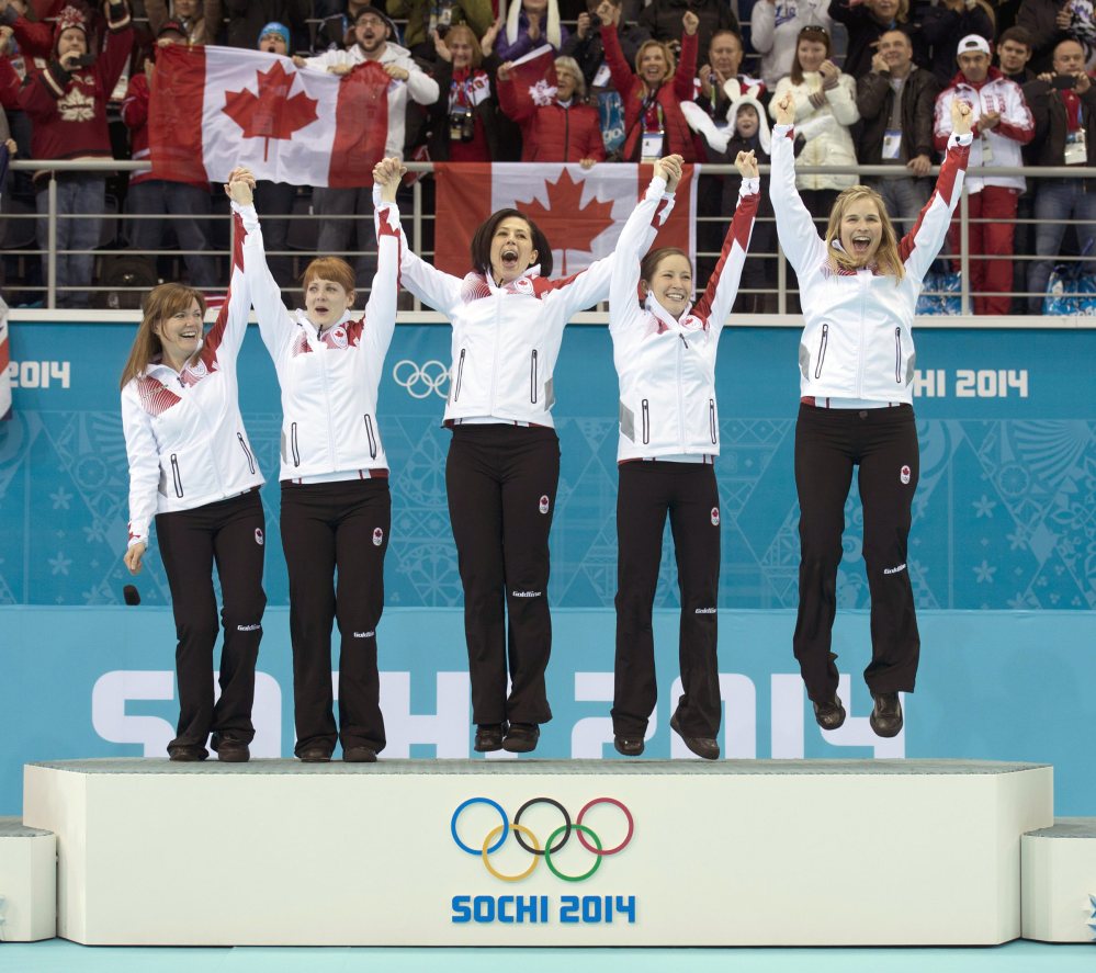 Canada’s women’s curling team as seen from left to right, Kirsten Wall, Dawn McEwen, Jill Officer, Kaitlyn Lawes and skip Jennifer Jones, celebrate on the podium after winning the women’s curling gold medal game against Sweden at the 2014 Winter Olympics, Thursday, Feb. 20, 2014, in Sochi, Russia.