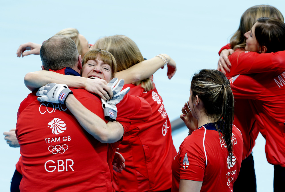 Britain’s Claire Hamilton hugs her coach as her team celebrates after beating Switzerland in the women’s curling bronze medal game at the 2014 Winter Olympics, Thursday, Feb. 20, 2014, in Sochi, Russia.