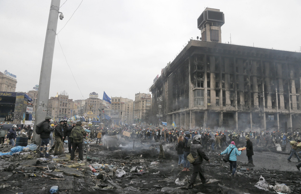 People pass through Independence Square in Kiev, Ukraine, Thursday. Fierce clashes between police and protesters shattered a brief truce in Ukraine’s besieged capital Thursday, killing numerous people.