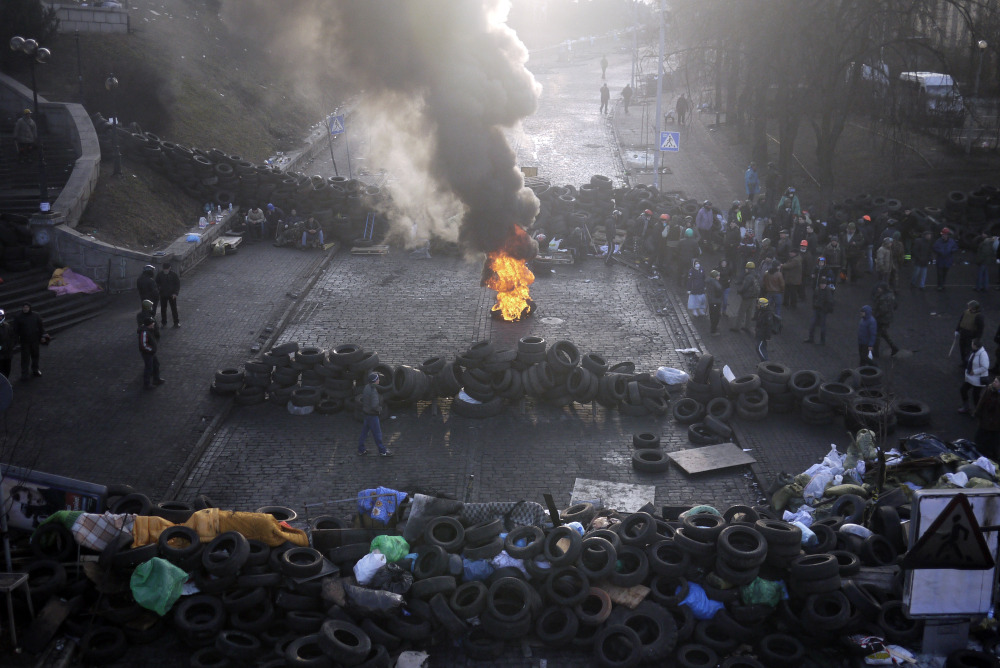 A fire burns at the barricades on the outskirts of Independence Square in Kiev, Ukraine, Friday. Ukraine’s presidency said Friday that it has negotiated an international deal intended to end battles between police and protesters that have killed scores and injured hundreds.