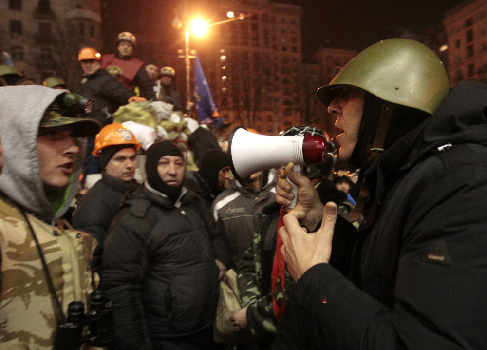 Opposition lawmaker Andriy Parubiy, right, tries to convince protesters to free a group of policemen, captured Thursday in Kiev. The policemen were eventually set free on Friday.