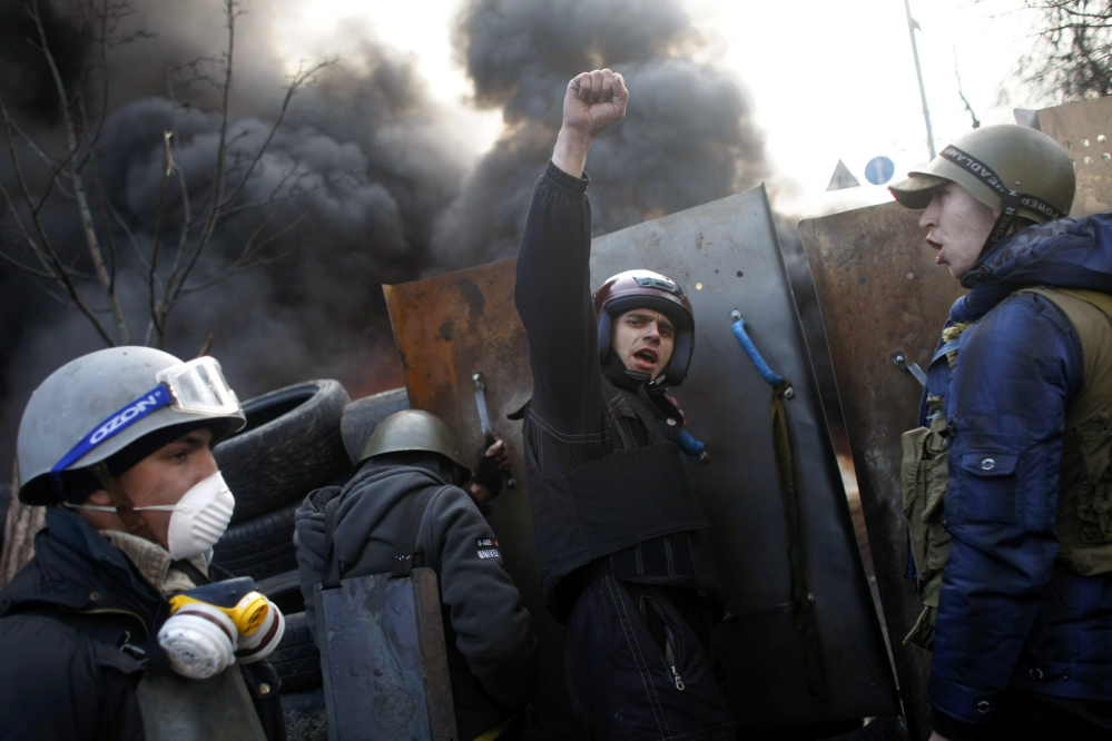 Anti-government protesters shout “Glory to the Ukraine” as they man a barricade at Independence Square in Kiev on Friday.