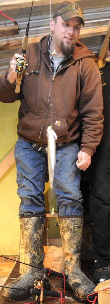 Low on smelt: Phil Tracy catches a rainbow smelt Wednesday at Baker’s Smelt Camps in Pittson. Tracy fished with his cousin, Will Tracy, on the Kennebec River.