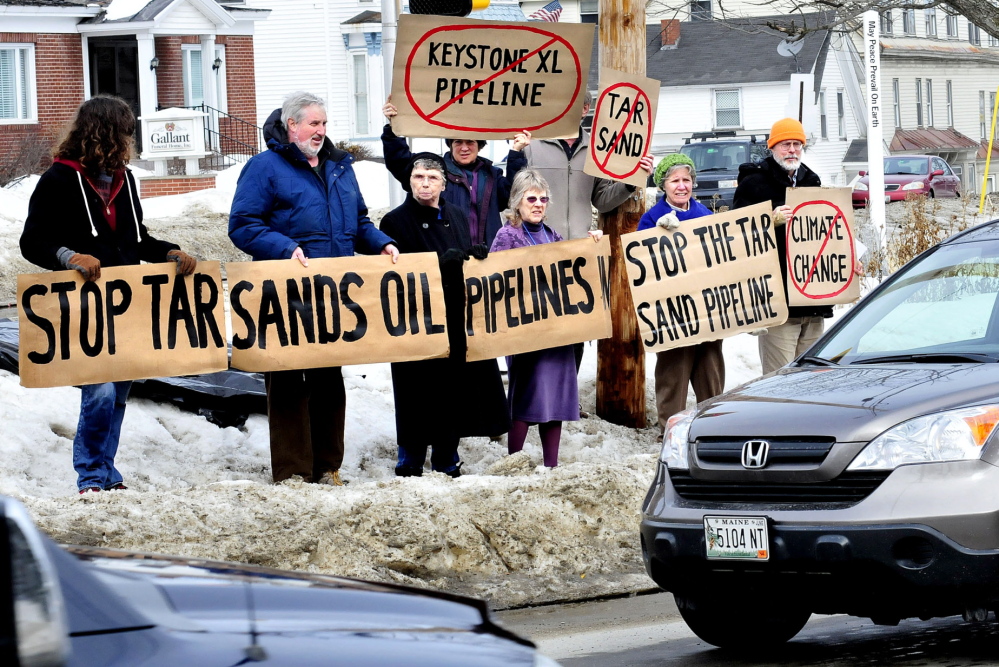 AGAINST: For the second time in February, this group of concerned citizens hold vigil against the proposed Keystone XL Pipeline on Sunday, Feb. 23, 2014, in front of the Universalist Unitarian Church in Waterville. From left in front are Anselm Scheck, Iver Lofving, Jane Edwards, Linda Woods, Marian Flaherty and Dick Thomas. In back are Cynthia and Paul Stoncioff.