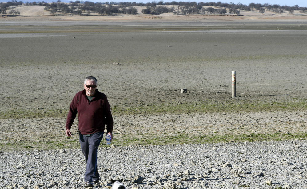 Leon Stout of Orland, Calif., walks across a dry Black Butte Lake near Orland Buttes Recreation Area in Chico, Calif., last month. Meteorologists forecast a pair of storms that could deliver much needed precipitation to parched California, a state that has just endured its driest year in recorded history. Several feet of snow are predicted for the Sierra Nevada.
