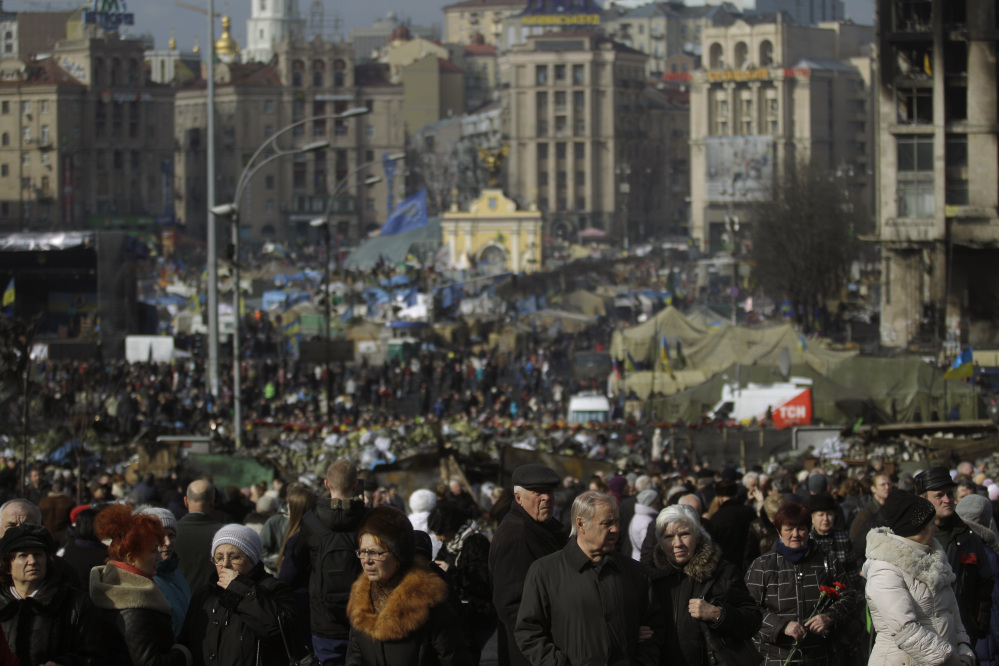 People flock to the Independence Square in Kiev, Ukraine, on Monday. Ukraine’s acting government issued a warrant Monday for the arrest of President Viktor Yanukovych, accusing him of mass crimes against protesters who stood up for months against his rule.