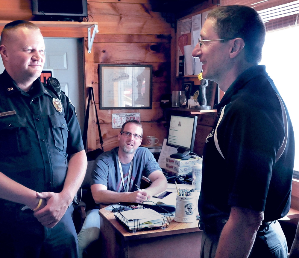 DEPARTMENT HEAD RAISES: Oakland police officer Todd Burbank, left, speaks with Chief Mike Tracy, right, as Capt. Rick Stubbert listens at the department last year. Pay for the positions of Tracy and Stubbert and six others town positions could increase if a proposed budget passes that includes increases in salaries equal to towns of similar sizes.