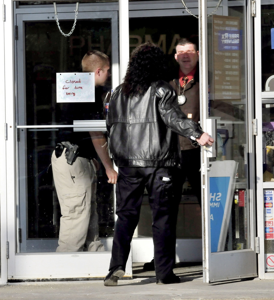 ROBBERY: Police officers open the door to the Rite Aid store in Winslow for Winslow Detective Gina Henderson shortly after the store was robbed on Monday. It was the second time in two years the store was robbed.