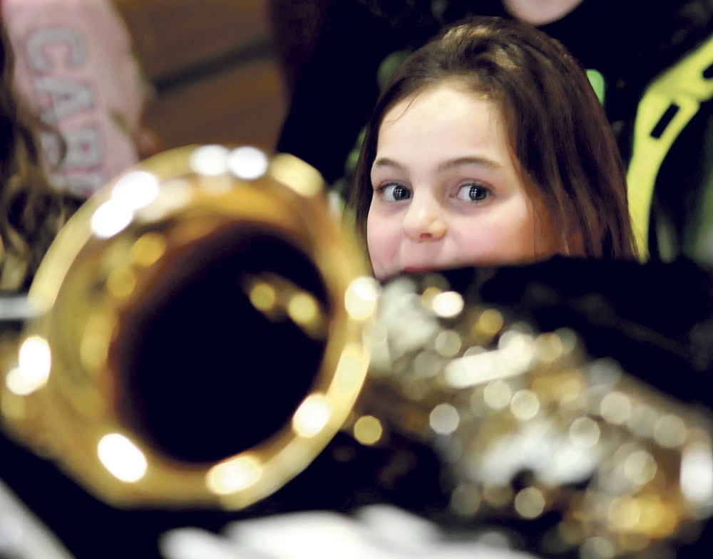 THE MUSIC GIRL: Quimby Middle School student Belle Farnham admires some of the musical instruments that were donated by the Cole Land Transportation Museum on Tuesday at the Bingham school.