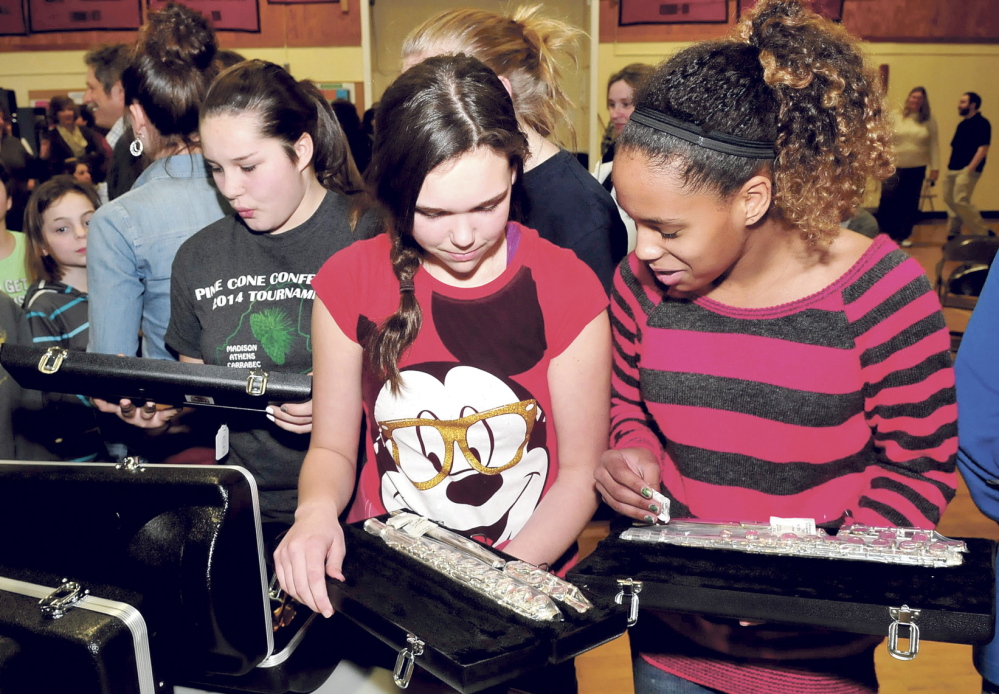 TAKING NOTE: Quimby Middle School students, from left, Ariana Dunton, Rianna Davis and Kendra Sweet look over flutes that were donated by the Cole Land Transportation Museum on Tuesday at the Bingham school.