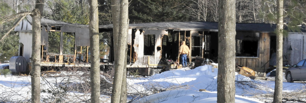 GONE: On Tuesday, a man looks into a mobile home at the intersection of Johnson Flat and Bush roads in Clinton that fire destroyed Monday evening.