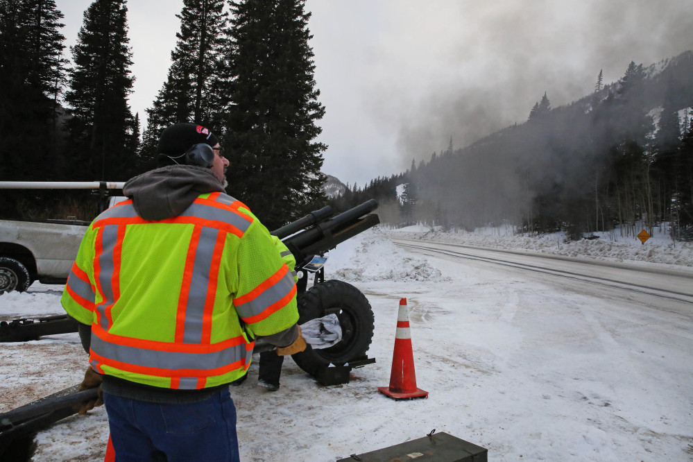 In this Feb. 21, 2014 photo, a Colorado Department of Transportation employee uses an explosives launcher to try to trigger a controlled avalanche, near Empire, Colo. Lots of new snow and strong winds in the past month have fueled dangerous conditions from the Cascades to the Rockies, prompting forecasters to issue warnings of considerable or high avalanche dangers for many areas outside of established ski areas. (AP Photo/Brennan Linsley)